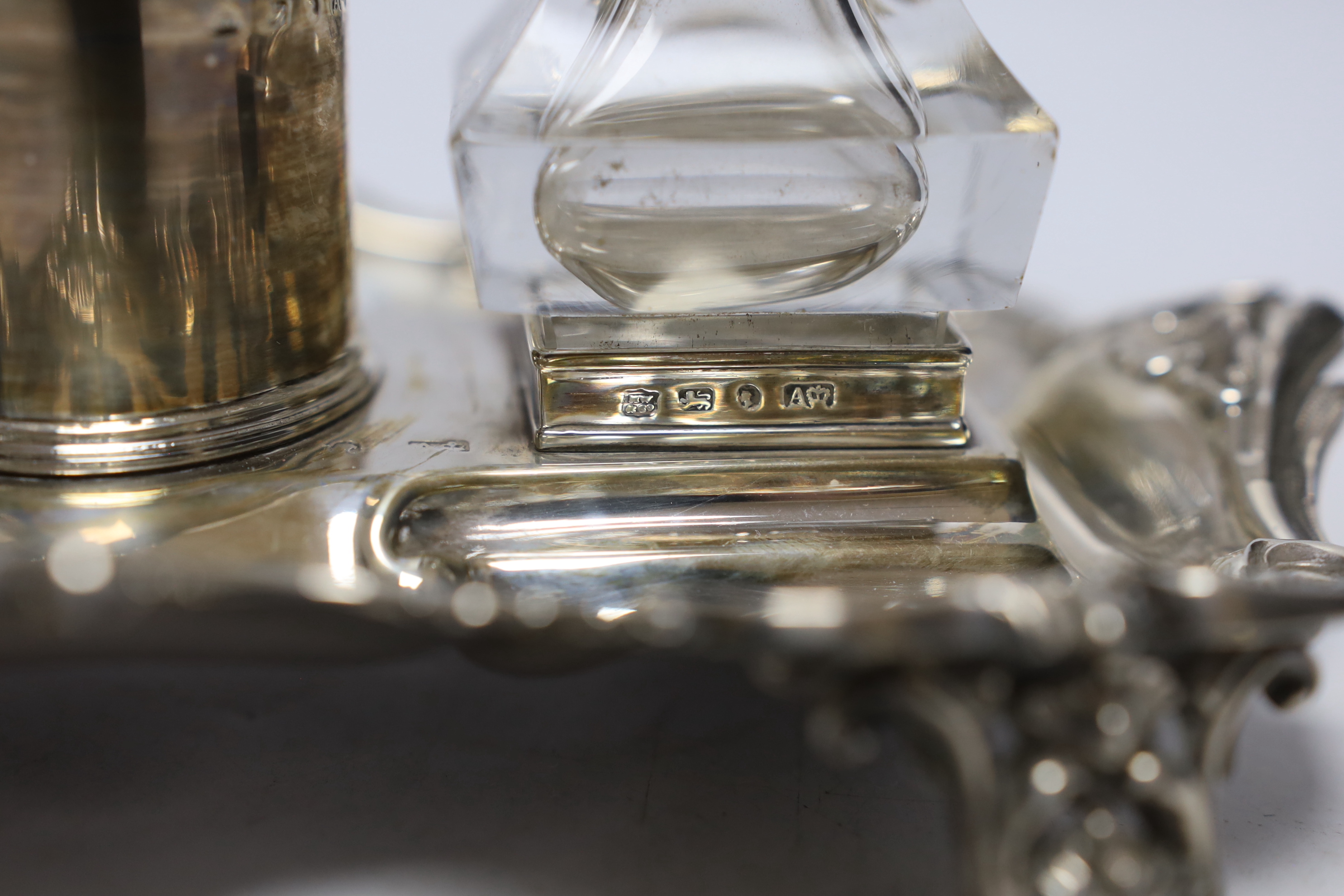 An early Victorian ornate silver inkstand, with two mounted glass wells and central taperstick, Henry Wilkinson & Co, Sheffield, 1844, 21cm